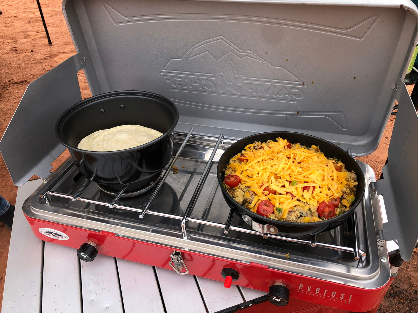 Delicious outdoor breakfast cooked on a Camp Chef camping stove with cheesy skillet and tortillas, ideal for your RV rental journey.