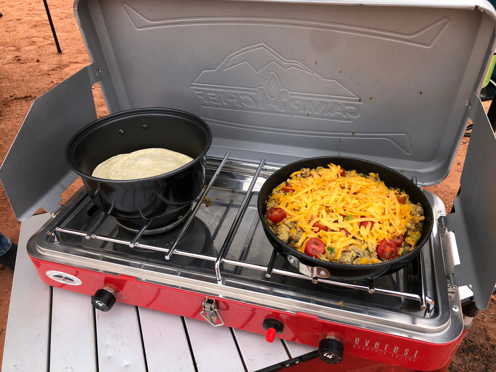 Delicious outdoor breakfast cooked on a Camp Chef camping stove with cheesy skillet and tortillas, ideal for your RV rental journey.
