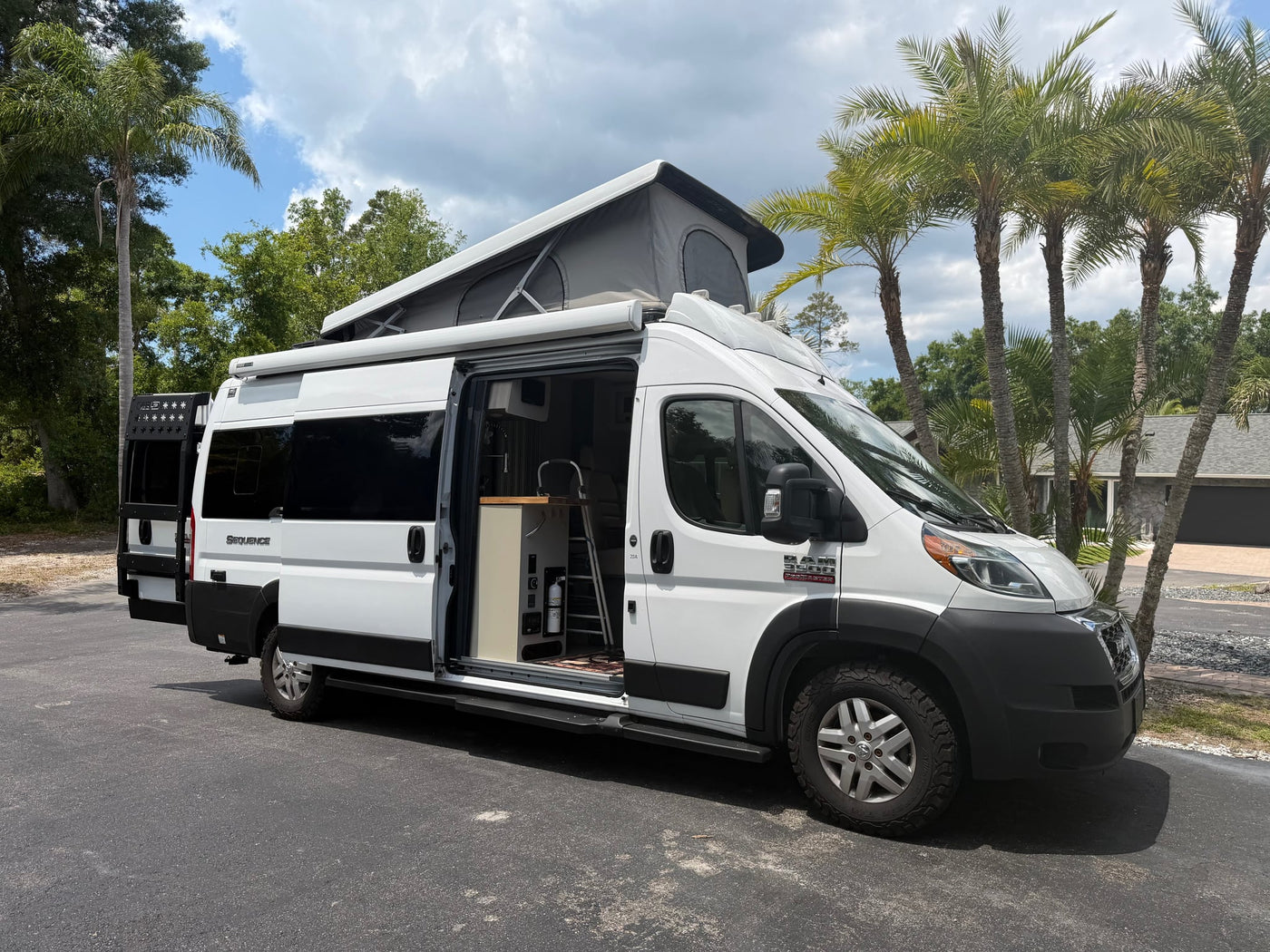 White pop-top camper van rv rental with open side door revealing interior kitchen — photo 1
