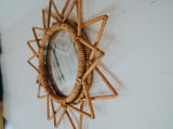 Cozy RV rental interior featuring a stylish, woven rattan sunburst mirror on a light wall, adding a boho touch.