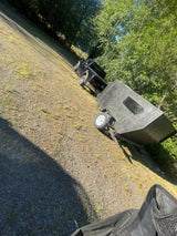 Black pickup truck with a small, rugged travel trailer on a gravel lot, perfect for your next outdoor rv rental trip.