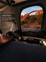 Warm camping in an RV rental: Pop-top tent with heating vent, overlooking a scenic arch & campfire.