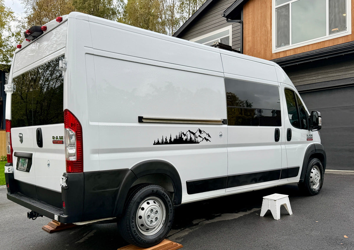 A white Ram ProMaster camper van, ideal for RV rental, with scenic mountain-forest decals parked at home. — photo 8