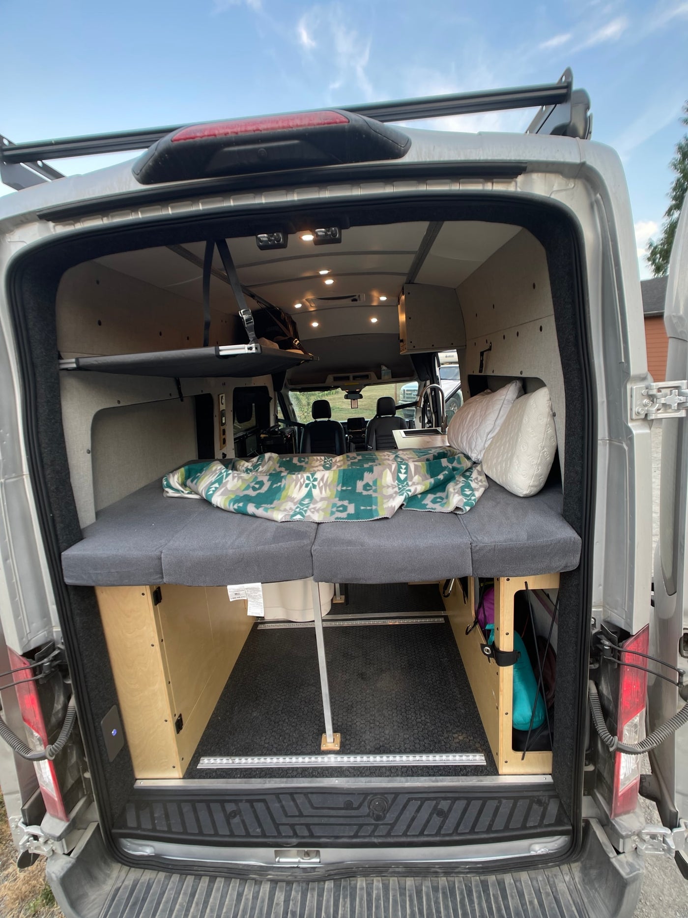 Inside a well-appointed camper van (RV rental) showcasing a bed, storage, and front cabin view. — photo 6