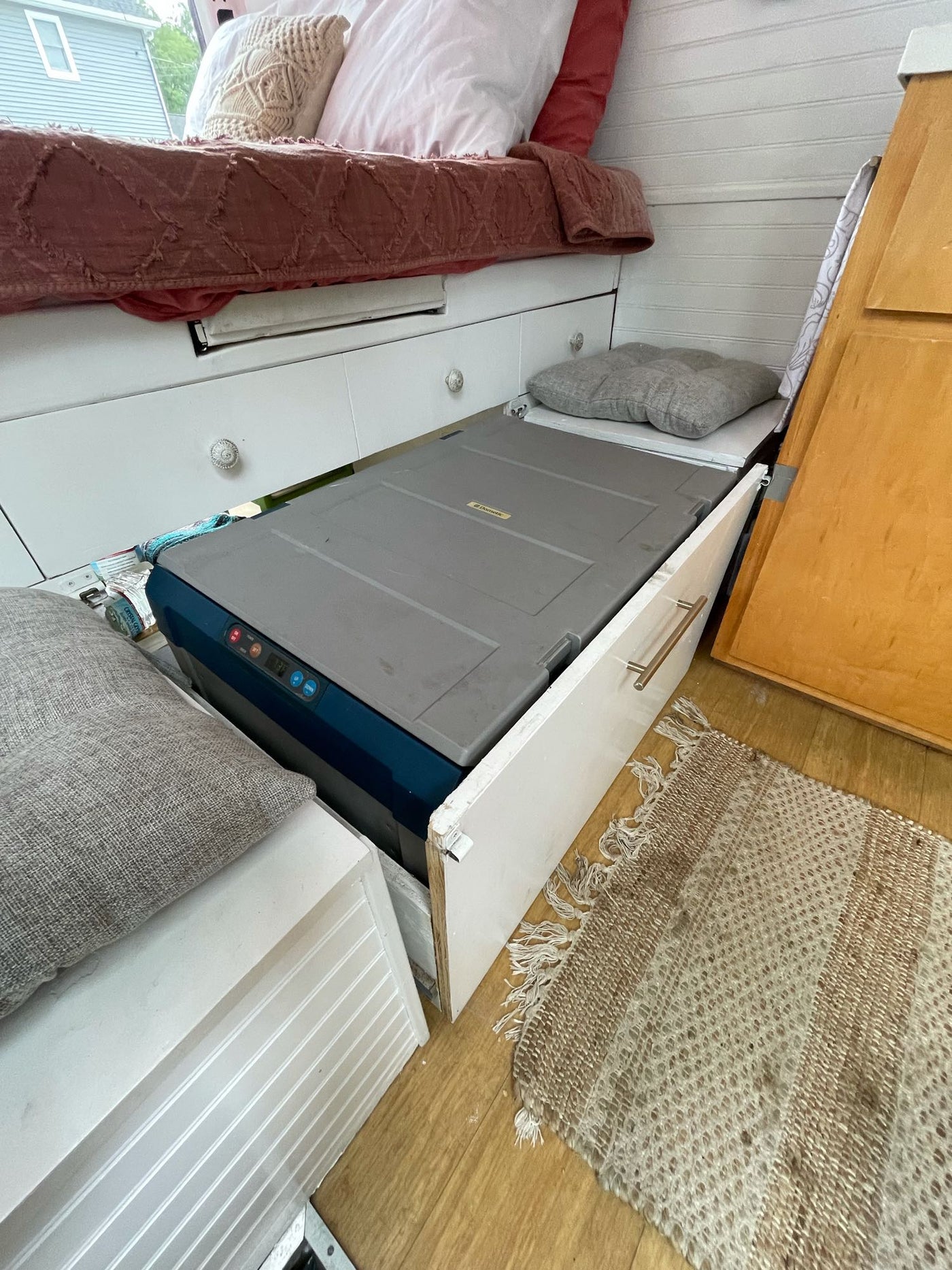 An RV rental's clever use of space: built-in bed storage, a slide-out Dometic cooler/fridge, and comfortable interior. — photo 8