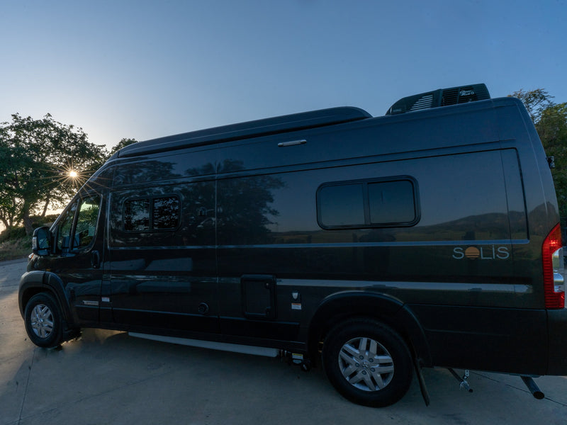 This sleek dark grey Winnebago Solis camper van rv rental is parked at sunset, ready for your next outdoor journey. — photo 8