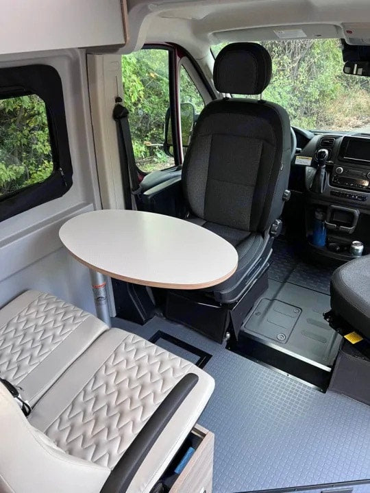  and innovative floor storage for comfortable travel.|An RV rental's interior features a compact dinette with light seating — photo 20