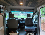 Inside an RV rental's front cabin: custom wood ceiling, comfortable front seats, and dashboard, ready for journeys.