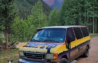  ideal for adventure travel.|This colorful RV rental van is parked on a dirt road in a lush mountain forest — photo 3