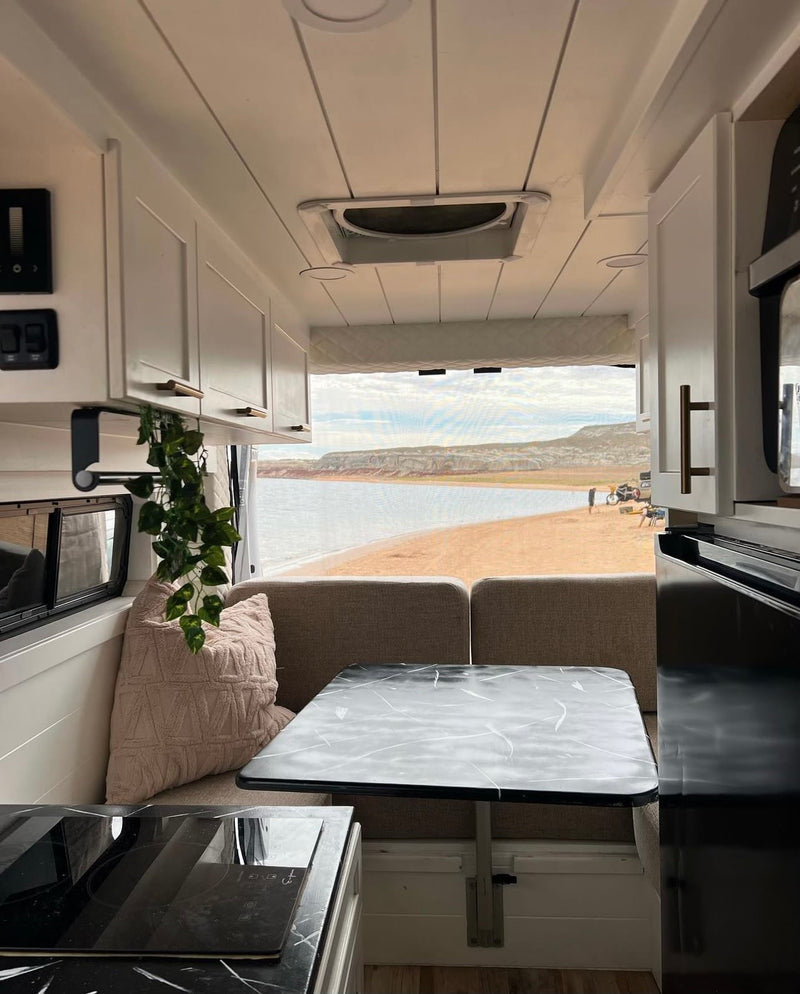 Inside an RV rental: a modern kitchen, comfortable dining area, and a stunning view of a lake beach. — photo 2