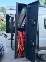 RV rental Sprinter van's rear storage bay, neatly packed with a Camp Roll Table and several red folding chairs.