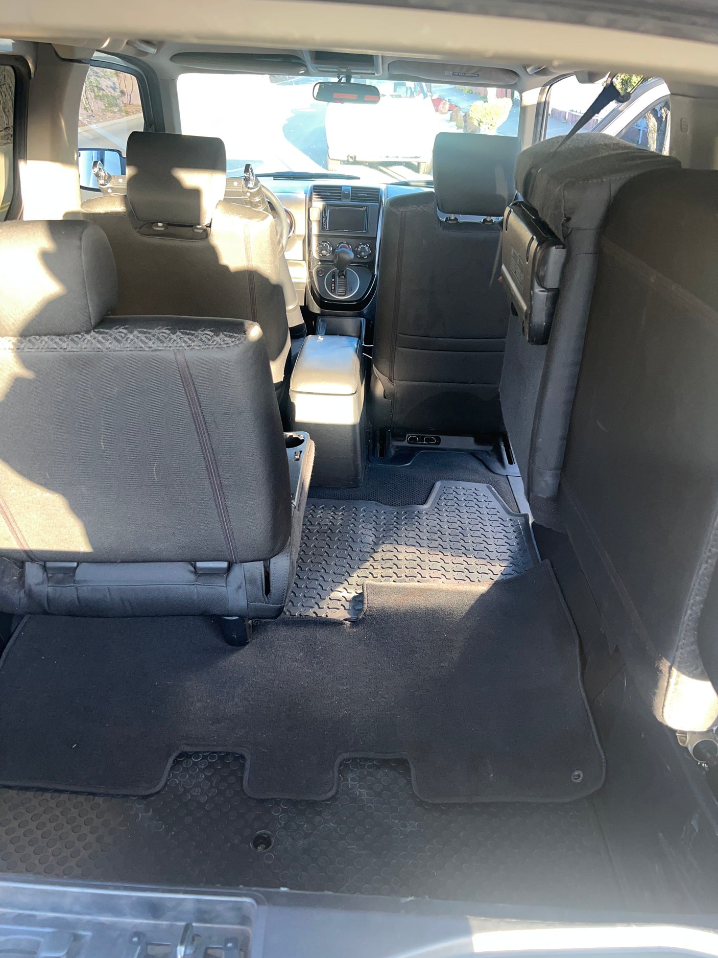 RV rental's spacious interior: black fabric seating, durable patterned floor mats, and a clear view of the front console.