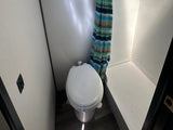  adjacent to a bed with built-in storage.|Compact RV rental bathroom features a toilet