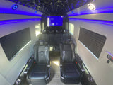 Luxury RV rental interior with black leather captain's chairs, blue LED lighting, a faceted ceiling, and entertainment screen.