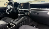 Inside a rugged Tacoma truck, with its digital dashboard, large infotainment screen, and practical center console, perfect for an RV rental trip.