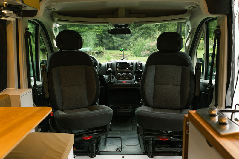 Inside an RV rental: view from living area to front cockpit with two seats & dashboard. Ready for van life travel. — photo 15
