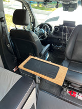 Inside an RV rental, featuring the front cabin with swivel seats, an adjustable table, and a visible fire extinguisher for safety.