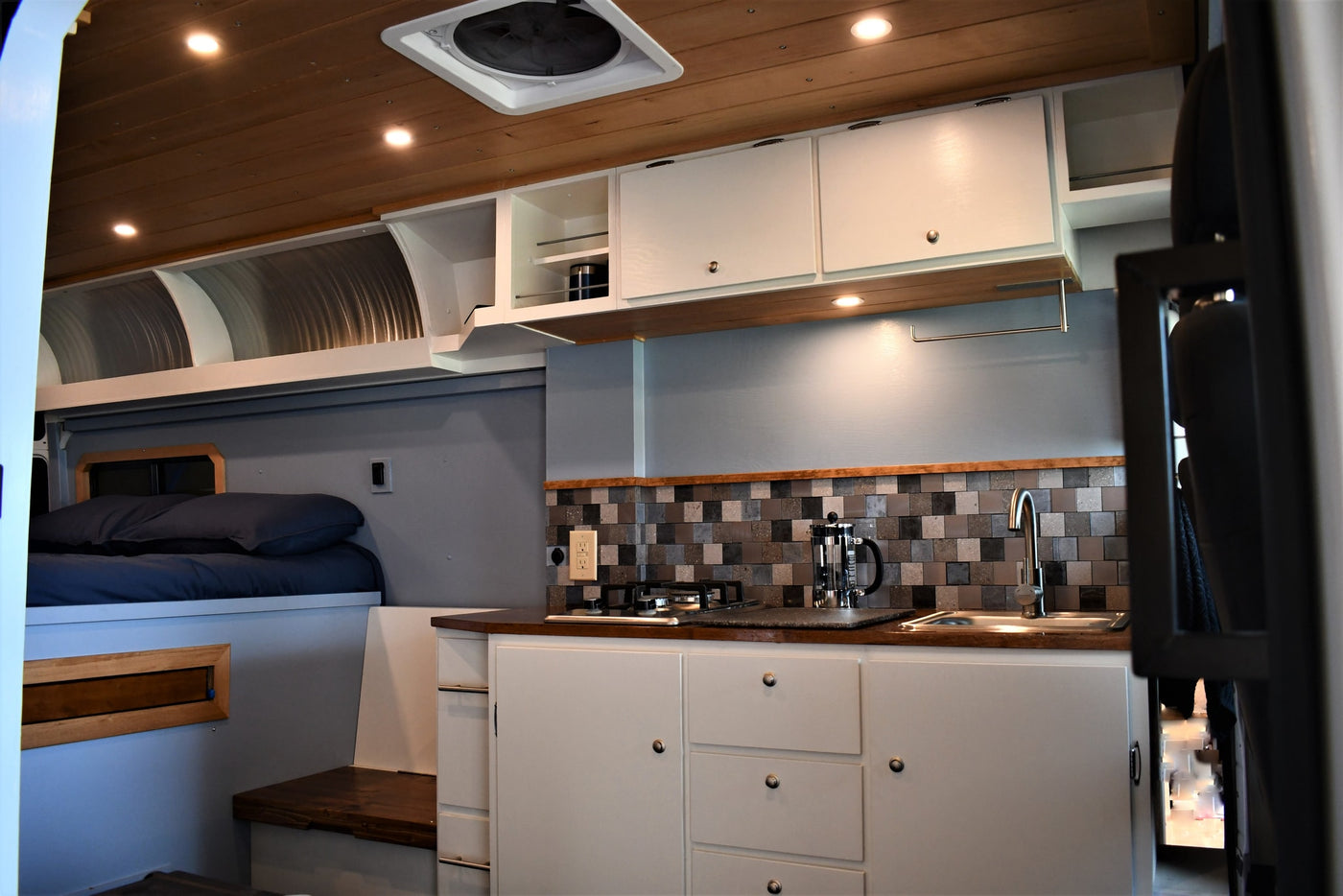 Cozy RV rental interior with compact kitchen, comfortable bed, and ample storage for your adventures. — photo 4