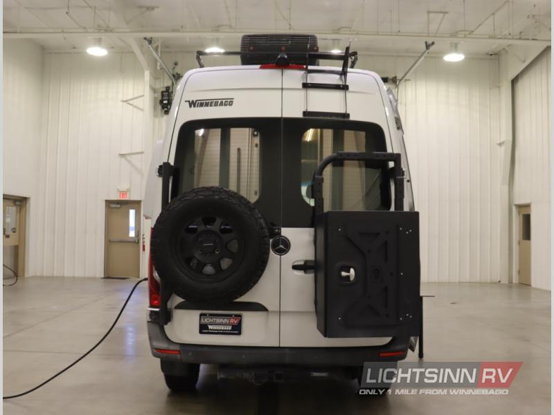  parked on a snowy street.|Explore this silver **rv rental** camper van with open doors — photo 4