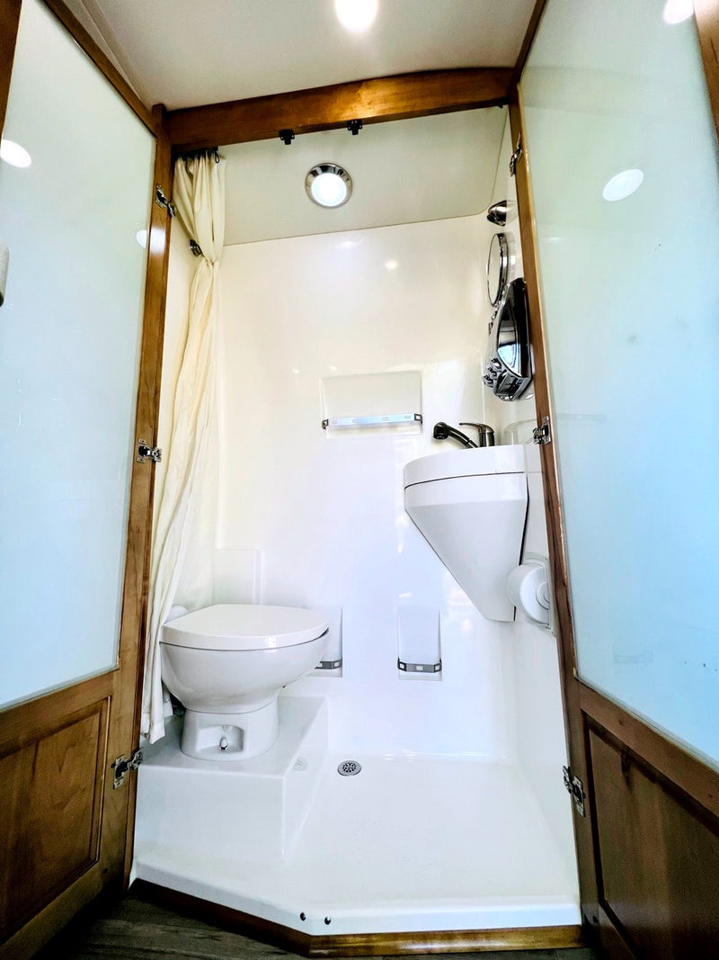 Compact RV rental wet bath with shower, toilet, and sink for comfortable travel convenience. — photo 18