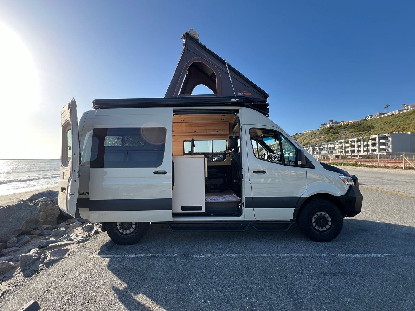  and a window view of a sparkling lake.|Step inside this modern rv rental van conversion — photo 8