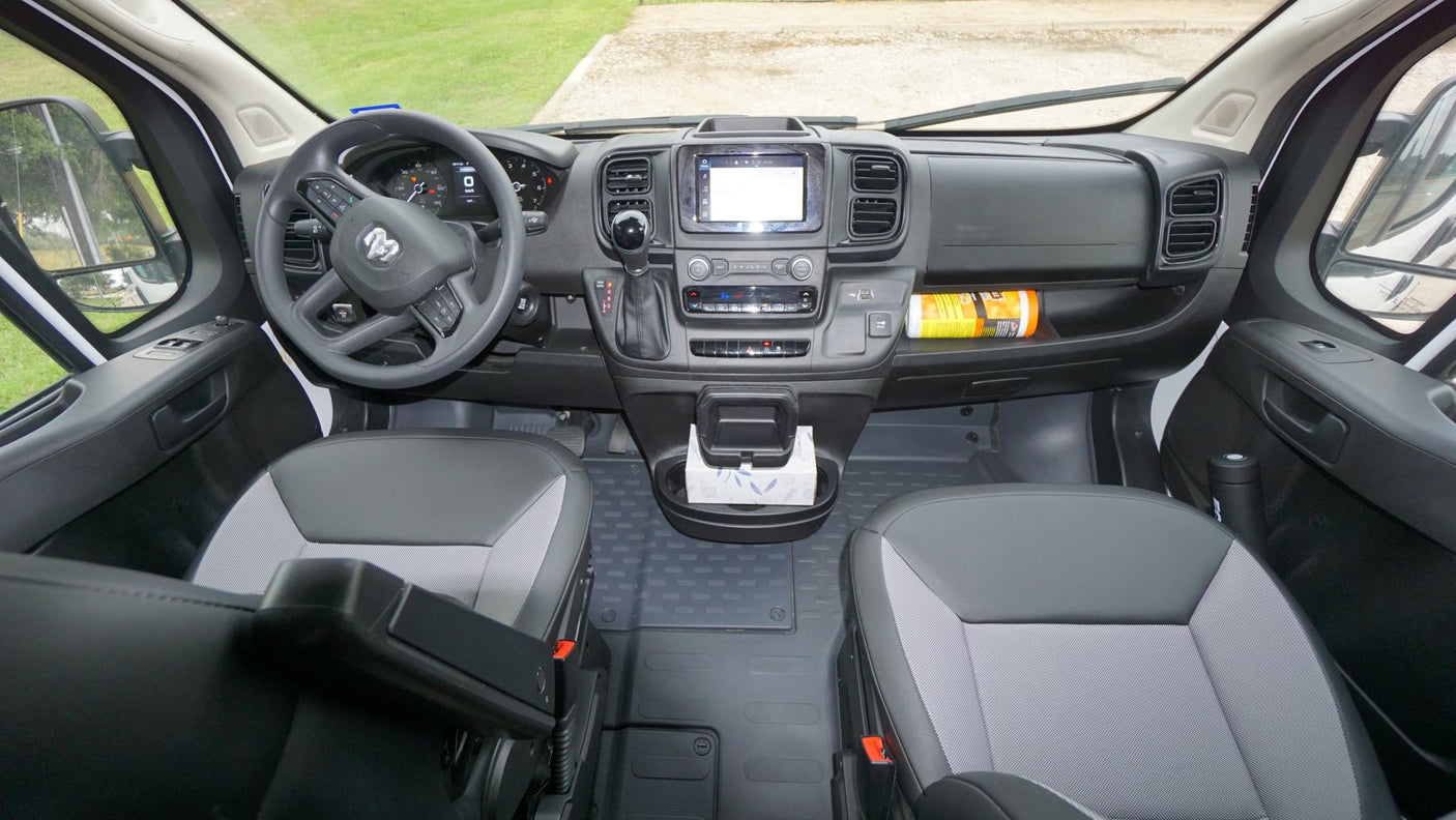 RV rental van interior: dashboard, steering wheel, infotainment, front seats, and center console. Clean & functional.