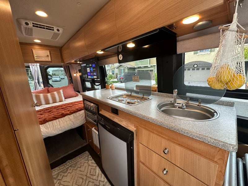 Step inside this cozy RV rental! Features a compact kitchen — photo 1