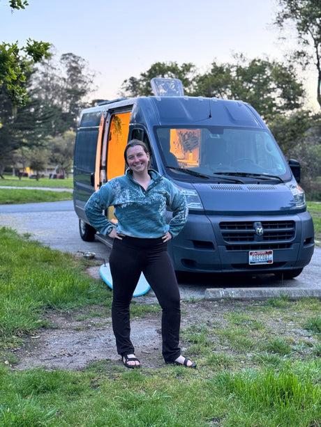 Smiling woman by her blue camper van with open interior. Ideal for an rv rental adventure or exploring van life.