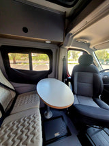 RV rental interior showcasing a modern camper van with comfortable seating and a dining table.