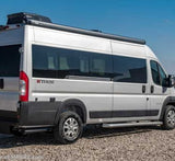 Ethos silver Class B RV rental parked on gravel. Features large tinted windows, a roof awning, and a side step.