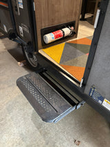 Exploring an RV rental: entryway with retractable steps, colorful mat, and a visible fire extinguisher for safety.