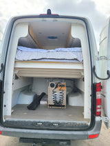 RV rental van interior: custom bed, under-bed storage, and a practical portable water system in the open rear hatch.