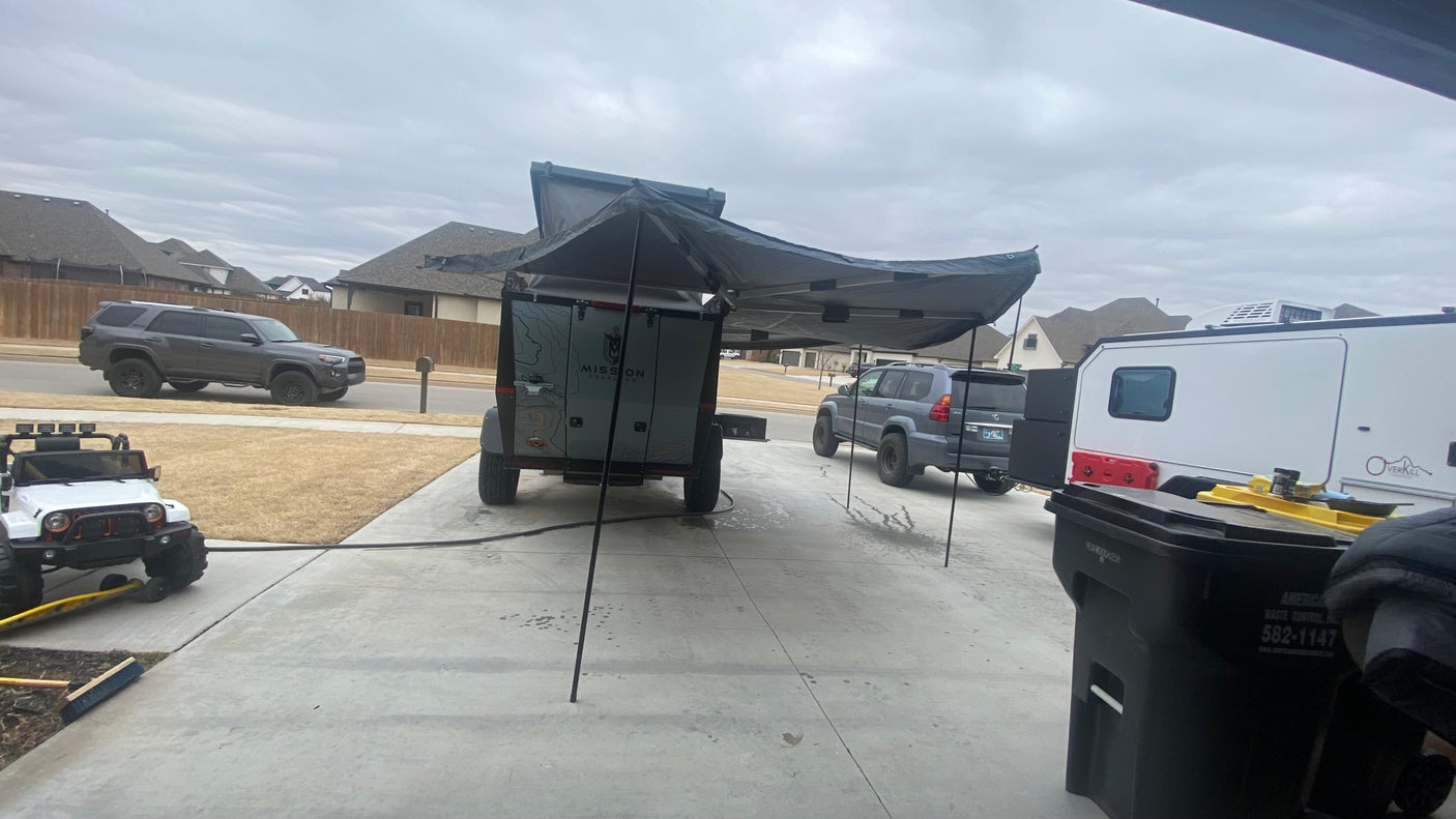 Overland camper, RV, and SUVs on a suburban driveway. Perfect for your next outdoor adventure or RV rental trip.