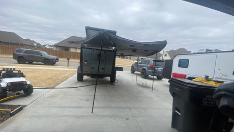 Overland camper, RV, and SUVs on a suburban driveway. Perfect for your next outdoor adventure or RV rental trip.