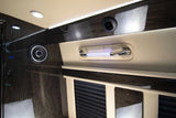 Luxury RV rental interior showing glossy dark wood, ceiling lights, a speaker, air vent, and an illuminated grab handle.