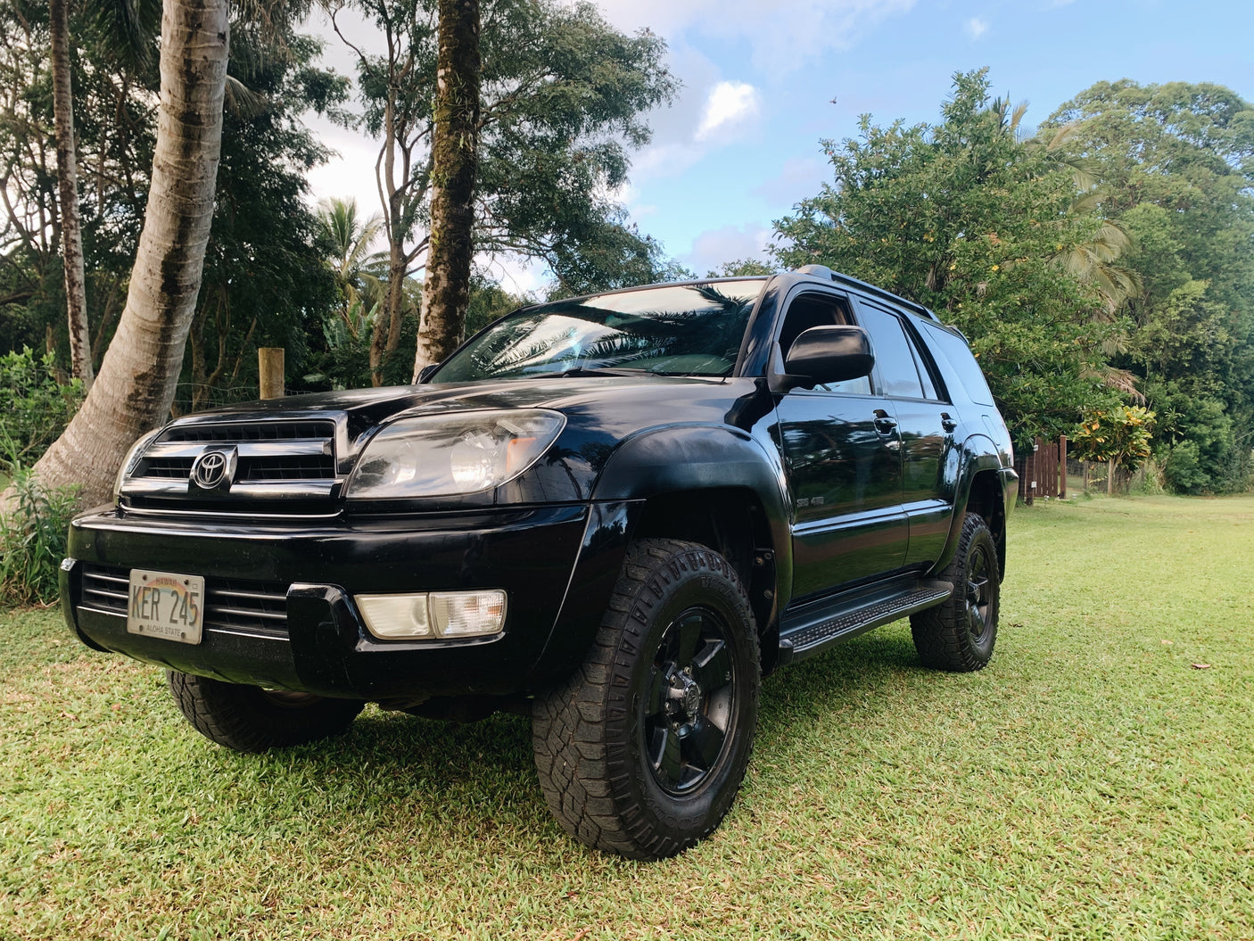 Black Toyota 4Runner 4x4 SUV (Hawaii plate KFR 245) on grass. A versatile option for outdoor trips, similar to an RV rental.