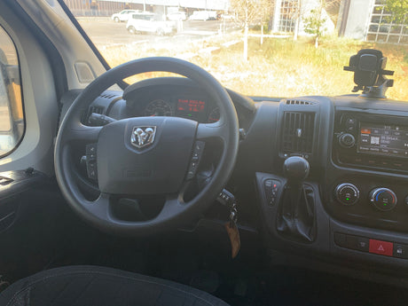 Interior view of a Ram van rv rental, showing the driver's dashboard, steering wheel, and infotainment system display.