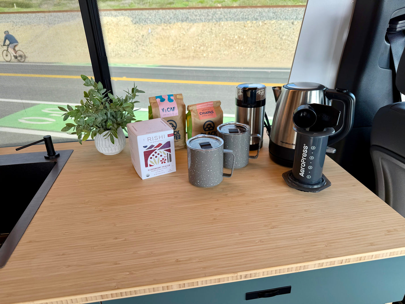 RV rental: Coffee & tea station with AeroPress, kettle, grinder, mugs, bags of coffee, and Rishi tea.