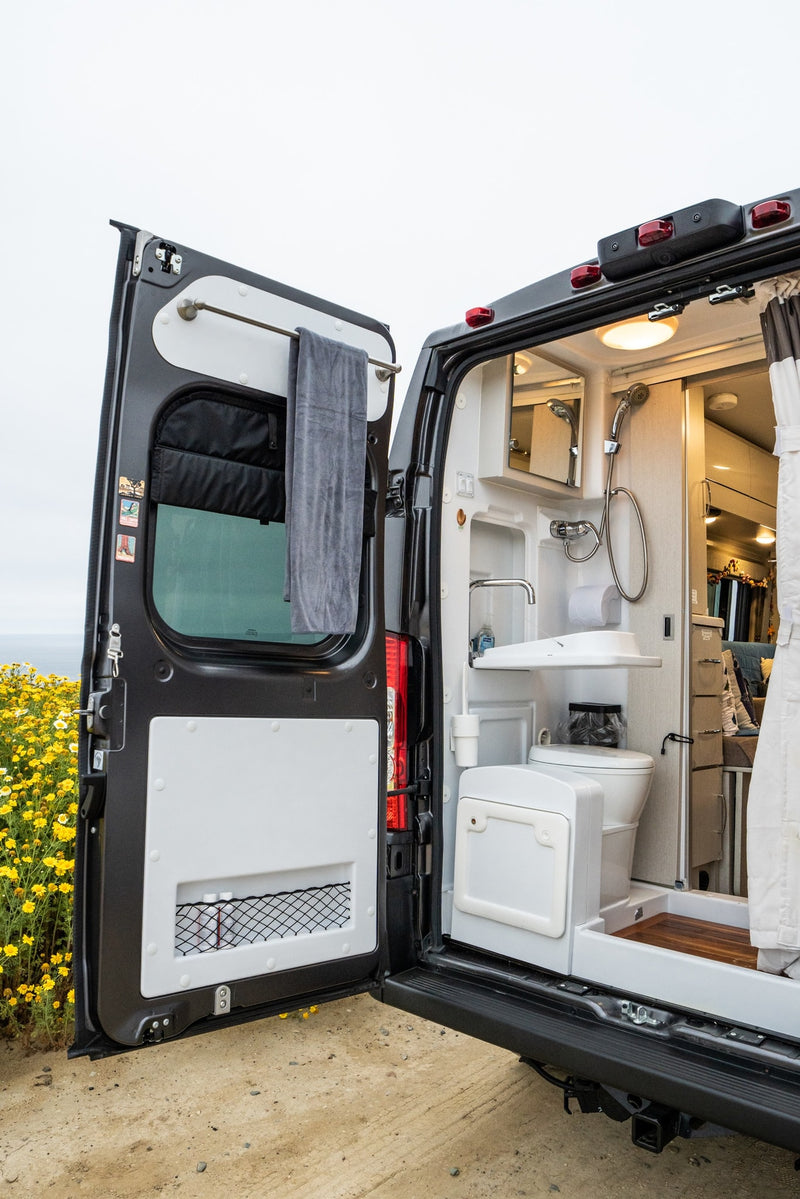 RV rental with open rear doors showing a compact, integrated bathroom (sink, toilet, shower). Perfect for mobile living. — photo 6