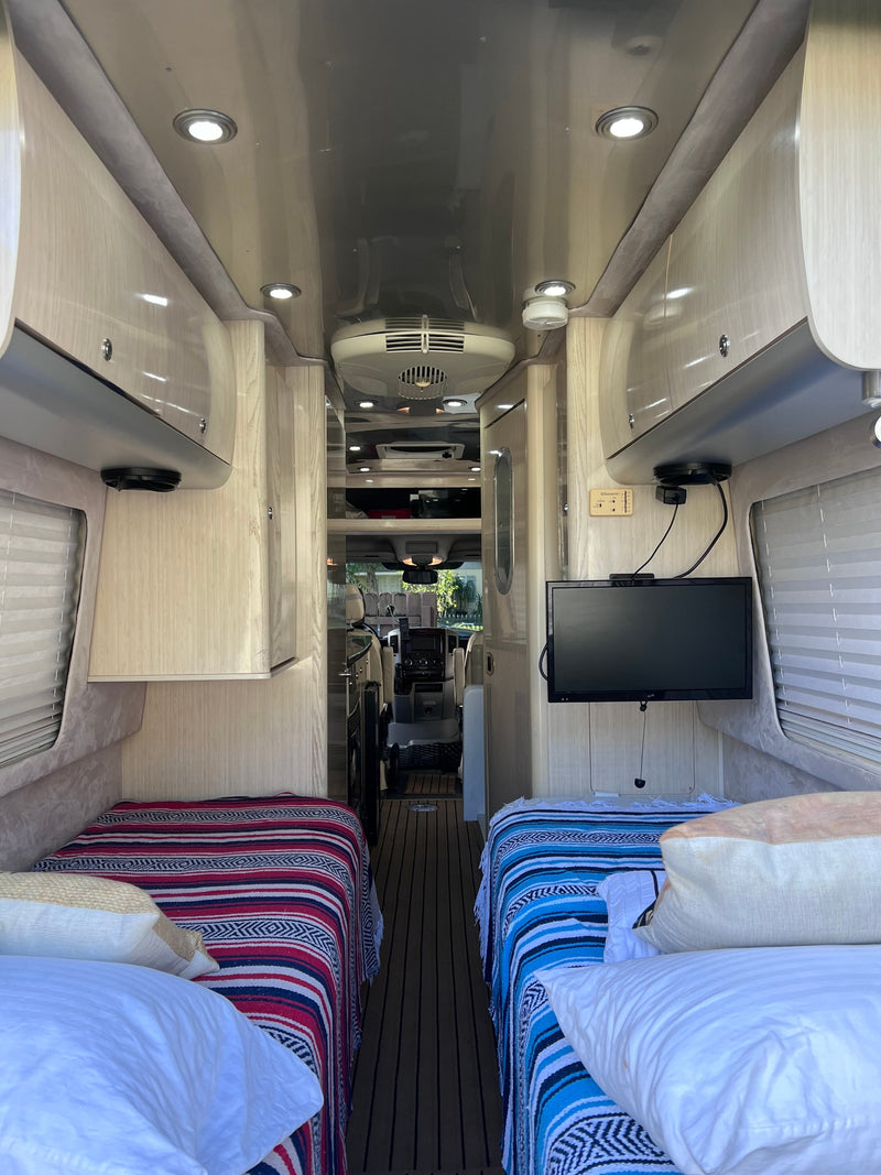  and overhead cabinets.|View inside an RV rental showing cream leather seats — photo 2
