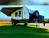 A sleek, white and black Ember travel trailer with an extended awning, ready for your RV rental adventure.