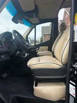 Luxury RV rental interior featuring premium cream seats and a well-appointed driver's area for comfortable travel.