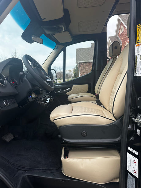 Luxury RV rental interior featuring premium cream seats and a well-appointed driver's area for comfortable travel.
