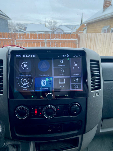 RV rental: Dashboard with Boss Elite Apple CarPlay screen & climate controls. Snowy neighborhood visible outside.