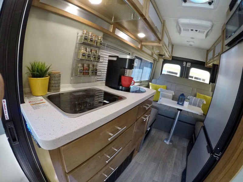  with hills in the distance. Ideal for coastal travel.|Step inside this modern RV rental! Features include a well-equipped kitchenette with stove and coffee maker — photo 5