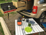 RV rental alternative: SUV with custom pull-out camping kitchen, stove, Jackery power, and portable dining setup.