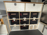 Organized rv rental storage: custom shelves, two drawers, and labeled bins for sports, bread, supplements, and dry food.