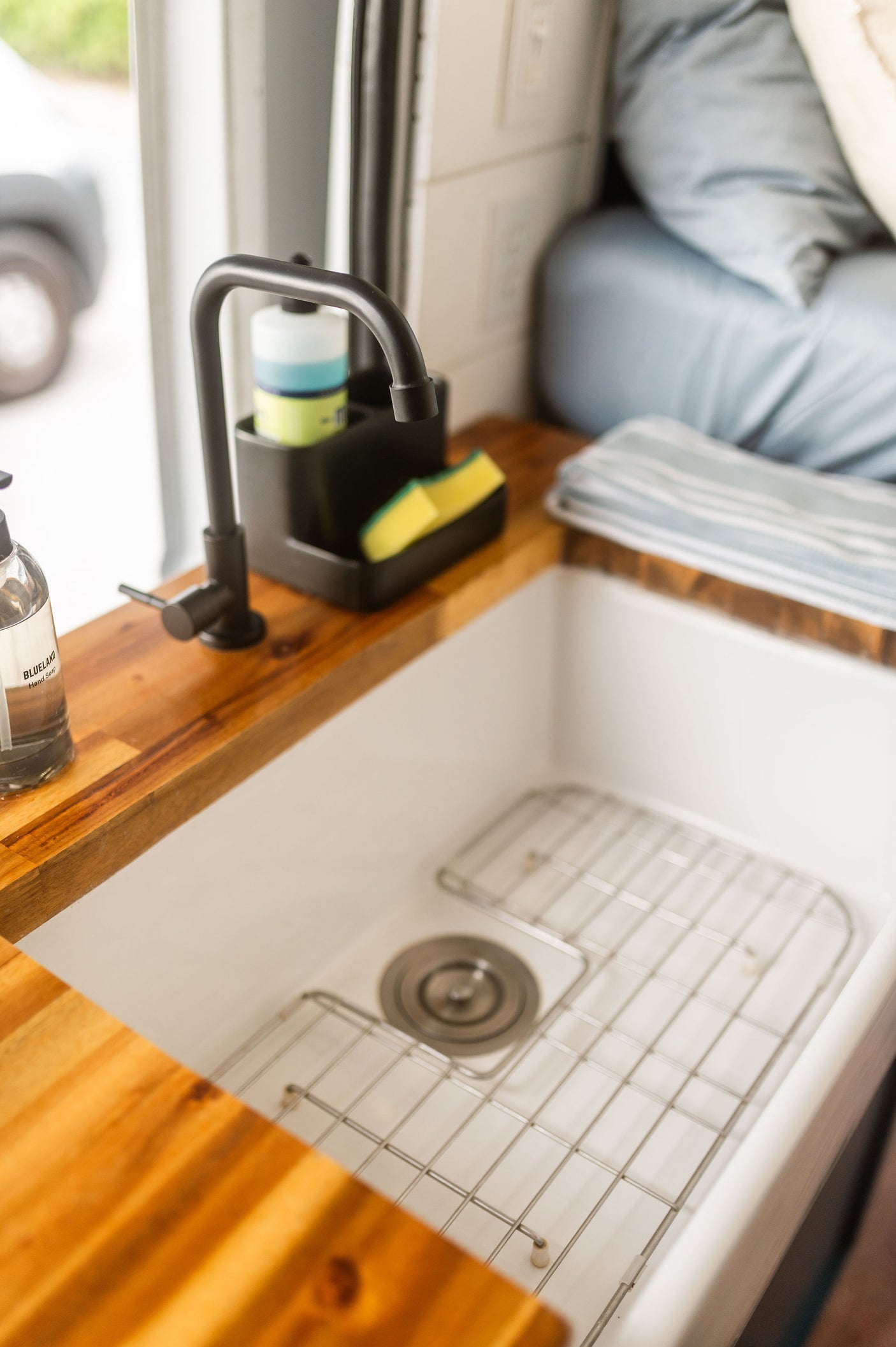 Modern RV rental kitchen: sleek sink, butcher block, and eco-friendly soaps for compact living.