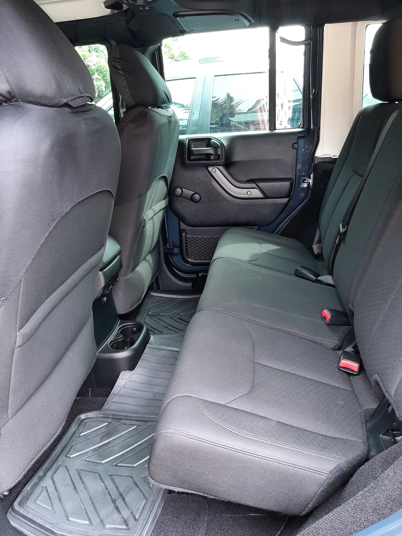 Rear cabin of an RV rental showing comfortable dark seats, cup holders, and durable floor mats. Ideal for travel.