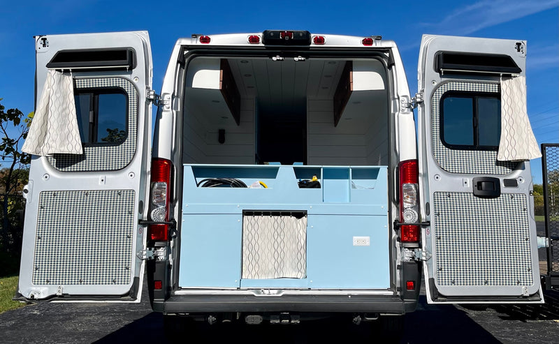 Open white camper van for RV rental, showing its custom light blue interior and patterned door panels. — photo 17